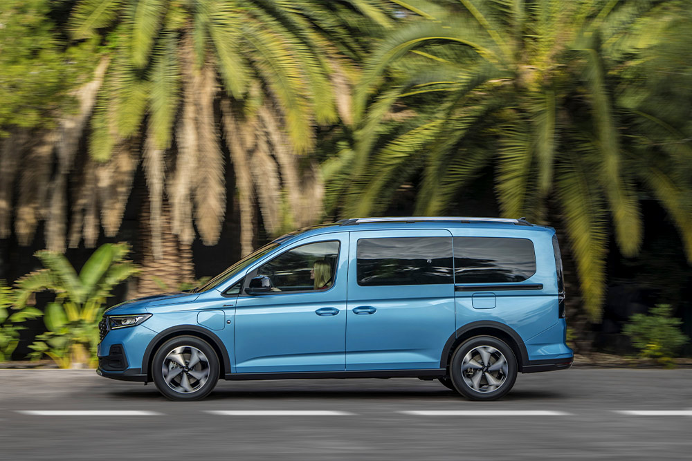 En blå Ford Tourneo Connect plug-in hybrid varebil parkert i en gate.