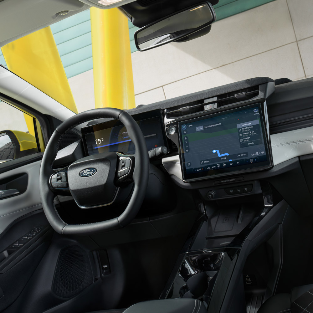 Interiørvisning av en Ford Puma, med nærbilde av rattet og touchskjermen.