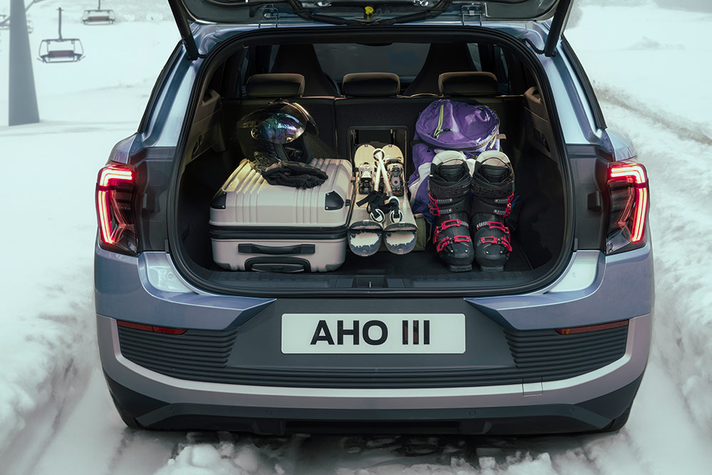 Bagasjerommet på Ford Explorer fylt med en hvit koffert og skiutstyr lastet gjennom skiluken.