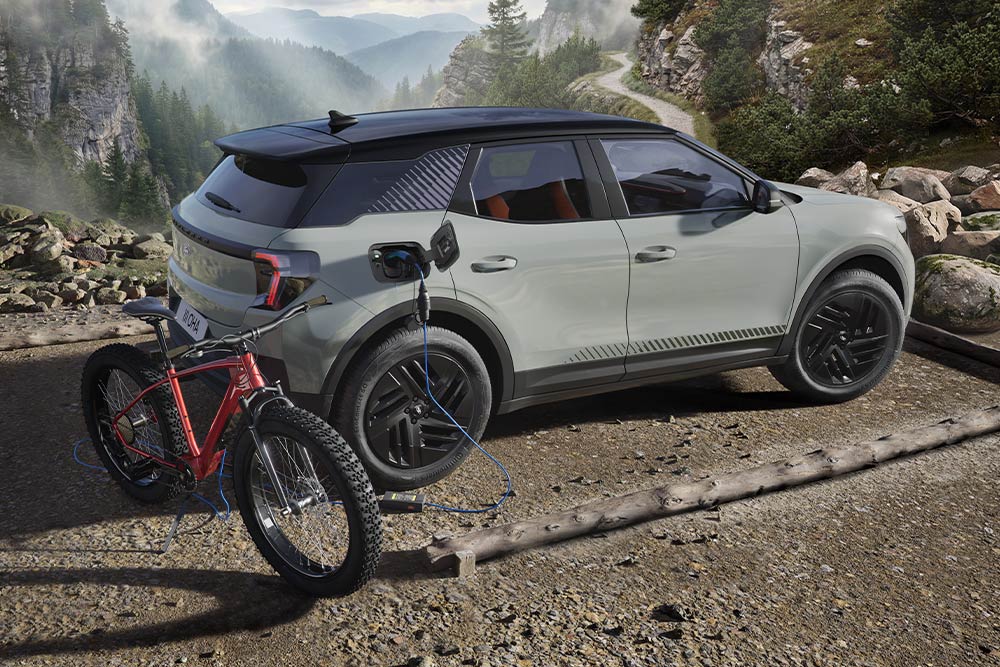 En elsykkel som lader på en Ford Explorer® med fjellandskap i bakgrunnen