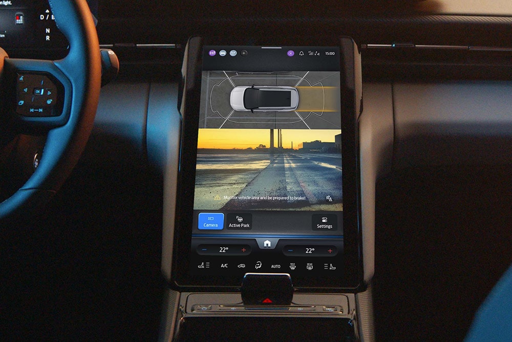 Nærbilde av den digitale berøringsskjermen i en Ford SUV, som viser aktiv-parkeringshjelp-systemet i bruk.