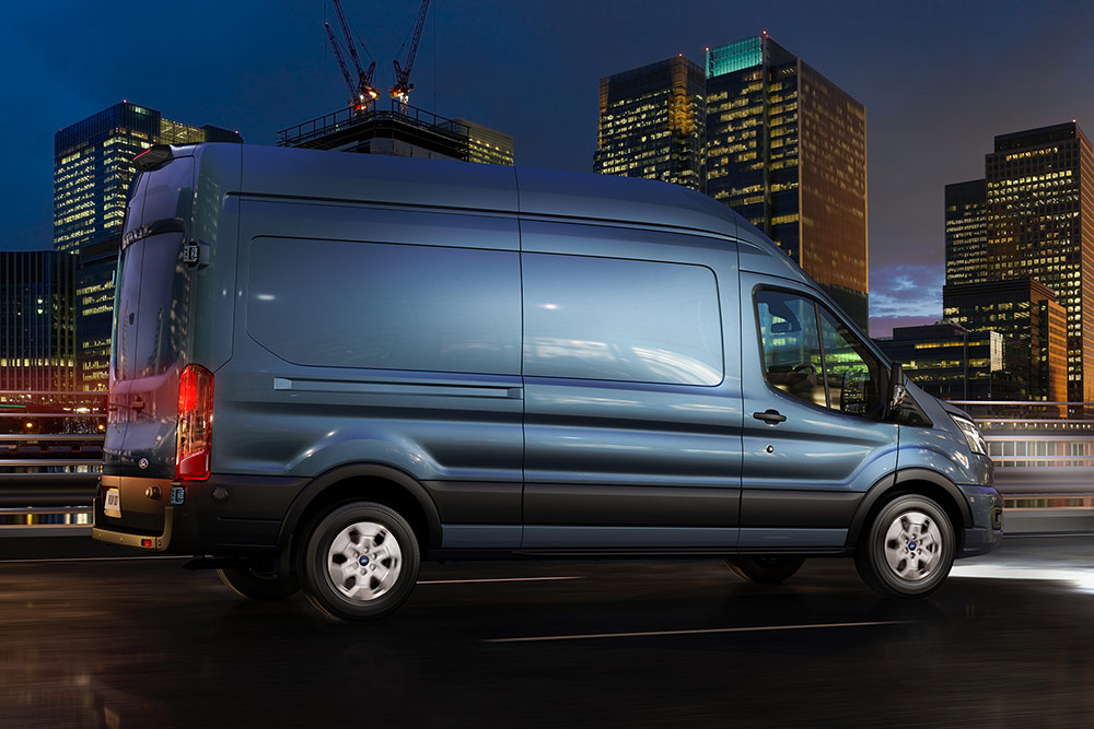 Ford Transit-varebil kjører i byen om natten.