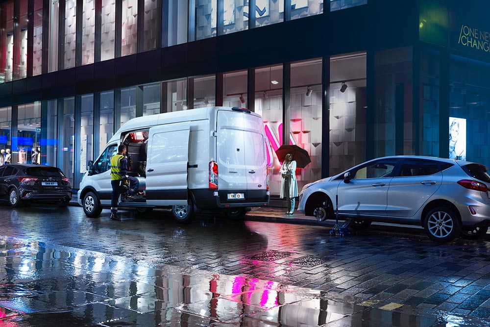 Ford Transit-varebil bergingskjøretøy parkert i en by om natten.