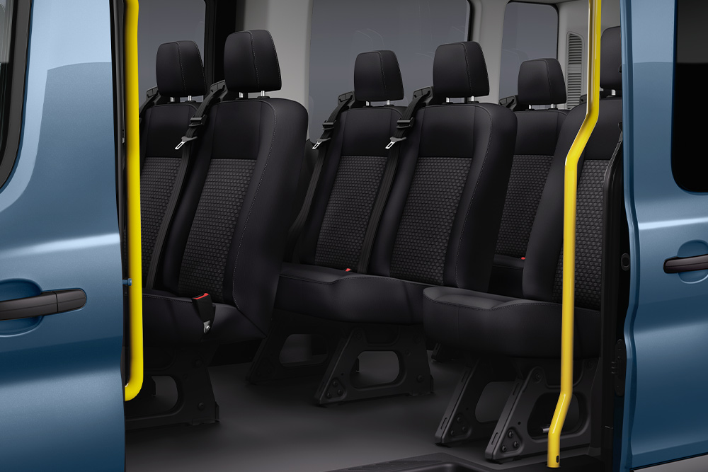 Visning av Ford Transit Kombi sine passasjerseter gjennom skyvedør på siden.