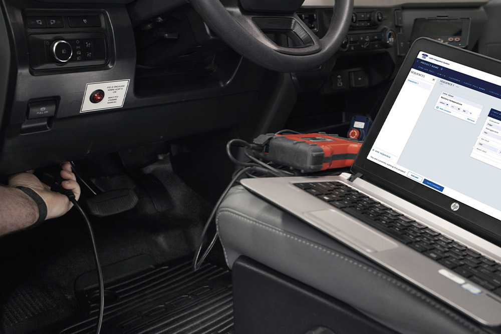 Nærbilde av bærbar PC koblet til et Ford kjøretøydashbord.