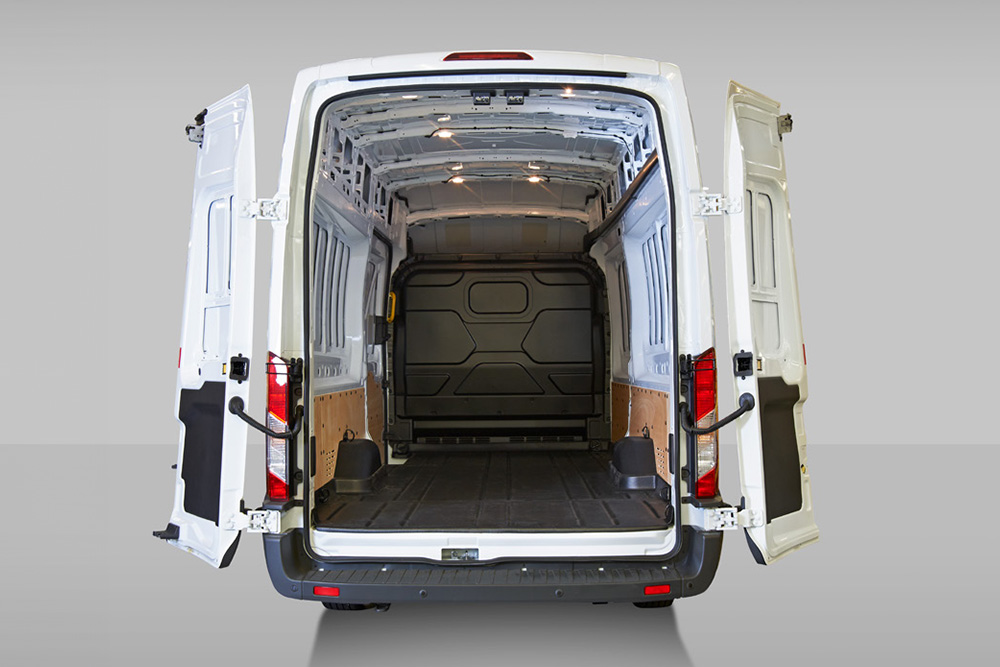 Bakfra-visning av innsiden av en hvit Ford Pro Transit varebil.
