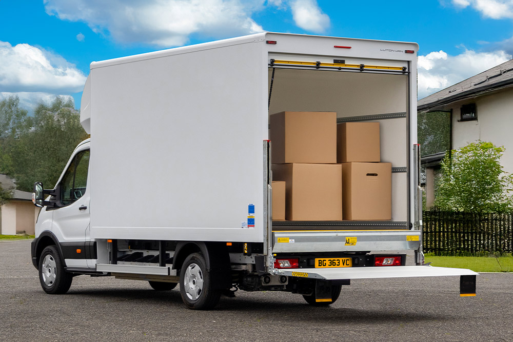 Bakfra-visning av en hvit Ford Pro Chassis Cab ombygd til en leveringsbil.