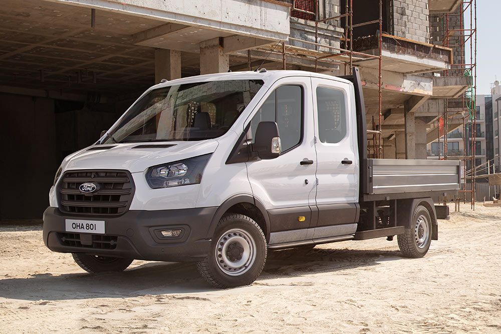 Hvit Ford Pro Chassis Cab parkert på en byggeplass ved siden av to bygningsarbeidere.