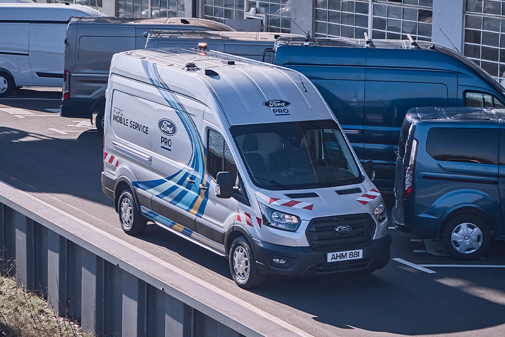En hvit Ford Pro Mobile Service varebil parkert på en varebilparkering.