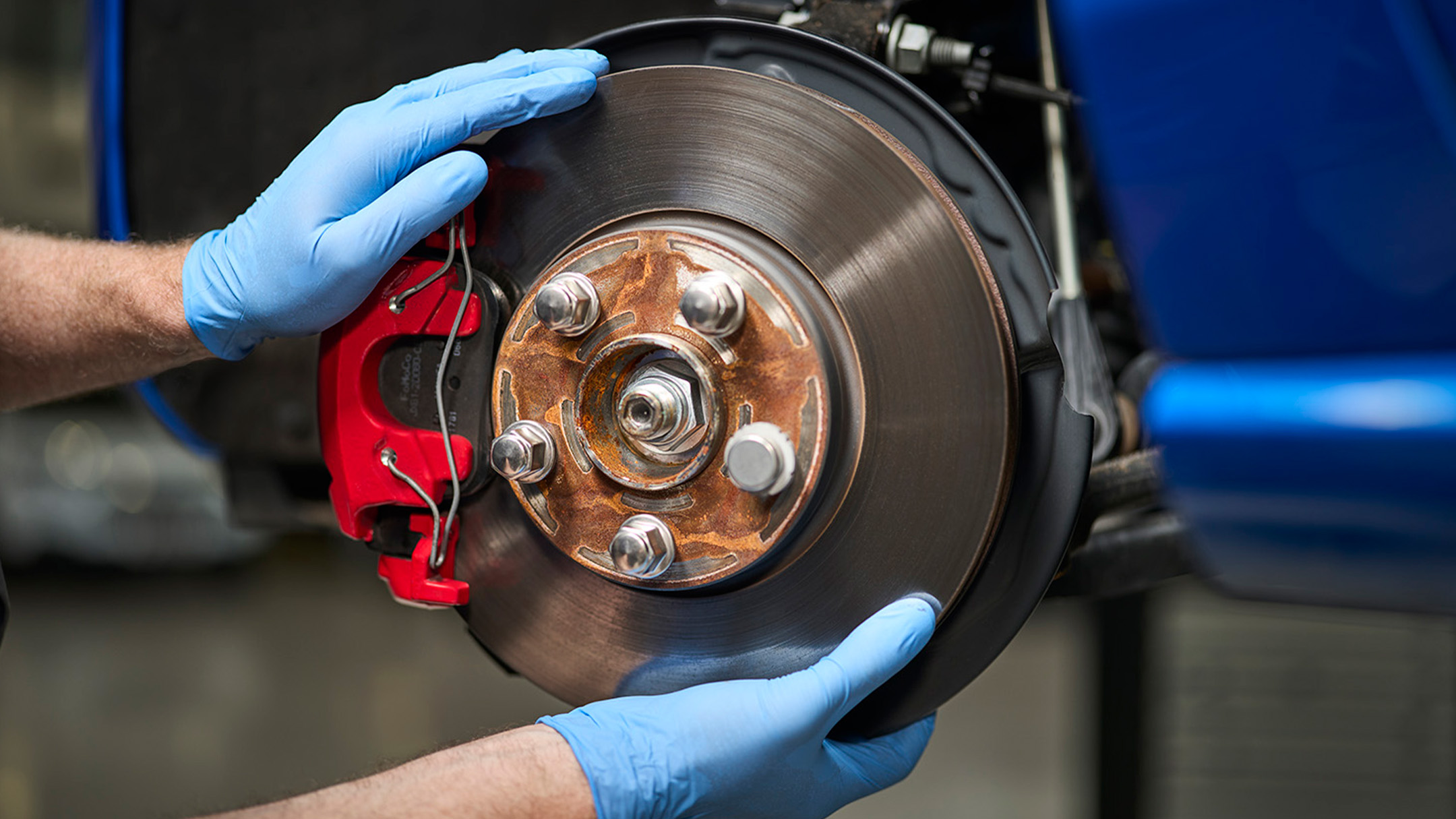 En mekaniker holder en Ford originaldel under en Ford Service og reparasjon