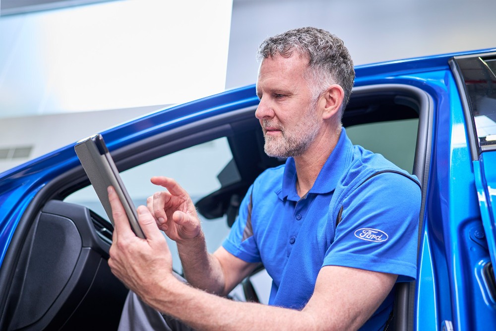 To Ford-servicemekanikeres inspiserer bilen